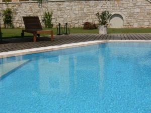 a large blue swimming pool with a chair next to it at Alkyon Villas in Syvota