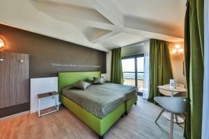 een slaapkamer met een groen bed en een raam bij Hotel Ideal in Sirmione