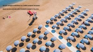 an overhead view of a beach with blue and white umbrellas at Villaggio Passo Dell'Arciprete in Vieste