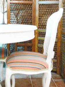 a white chair with a striped seat in a library at Alkyon Villas in Syvota