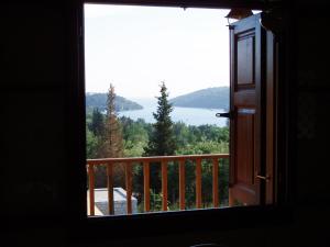 a room with a window looking out at a lake at Alkyon Villas in Syvota