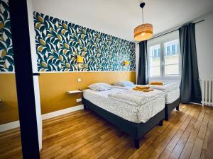 a bedroom with two beds and a wall mural at Gite Au Bord De Vire in Pont-Hébert
