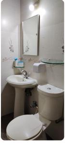 a bathroom with a toilet and a sink and a mirror at 1 Bedroom in Service Apartment in Aundh in Pune +6 photos