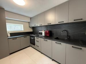 a kitchen with white cabinets and a microwave at Casa Maya in Băile Govora