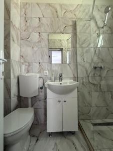 a white bathroom with a toilet and a sink at Casa Maya in Băile Govora +36 photos