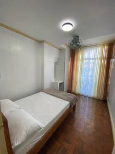 a bedroom with a bed and a large window at LJ's Burnham Homestay in Baguio