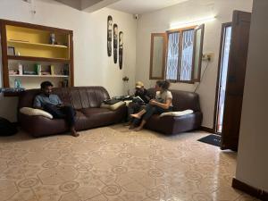 a group of people sitting on couches in a living room at Hostel Madras in Chennai