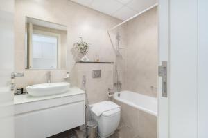 a bathroom with a sink and a toilet and a tub at Majestic Studio in Damac Carson C in Dubai Marina +41 photos
