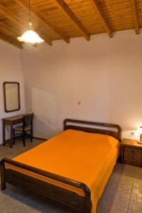 a bedroom with a bed and a table with a chair at Villa Panorama in Moúdhros