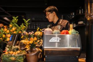 a man standing behind a counter in a kitchen at Phen Art House, Artistic Living in the Heart of Old Quarter in Hanoi