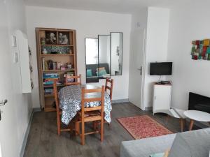a living room with a table and chairs and a television at Gîte Ty an Aod - 3 étoiles in Plougrescant