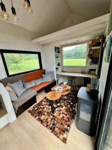 a living room with a couch and a table at Tiny House Malou in Modave +24 photos
