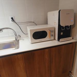 a microwave sitting on top of a kitchen counter at Stay Aall Seoul Train Station 2 in Seoul +23 photos