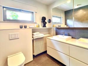 een badkamer met een wastafel en een toilet en een raam bij B&B near Ghent in Merelbeke +12 foto's
