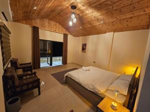 a bedroom with a bed and a table and a chair at Ramses Tafilah Lodge نزل رمسيس الطفيلة in At-Tafilah