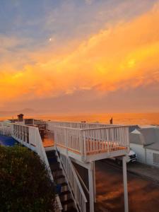 un paseo marítimo que conduce a la playa al atardecer en Point Village Accommodation - Snowdove, en Mossel Bay