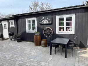a black shed with a table and chairs in front of it at Suncity Solsidan in Borgholm +1 photo