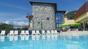 una piscina con sillas y un edificio en Hotel Bungalows Europa en Domaso