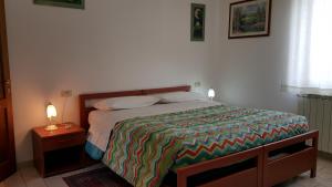 CannaraにあるB&B Barbara Assisiのベッドルーム1室(カラフルな掛け布団付きのベッド1台付)
