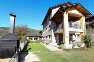 uma grande casa de pedra com um alpendre e uma varanda em El Jardí Casa rural ideal para familias y grupos em Arfa