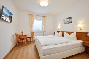 ein Hotelzimmer mit zwei Betten und einem Tisch in der Unterkunft Gästehaus Zugspitz - Zimmer ohne Verpflegung in Farchant + 8 Fotos