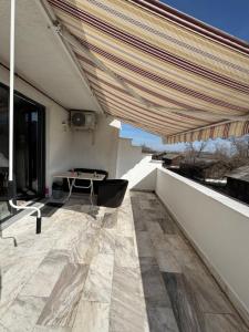 een patio met een tafel en luifel op een gebouw bij Apartments 1 Mamaia Nord in Mamaia Nord – Năvodari +4 foto's