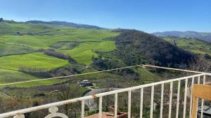 a balcony with a view of a green hill at Lupara Bella 