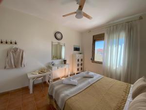 a bedroom with a bed and a table and a clock at Daylight in Nea Skioni