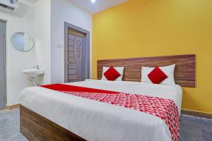 um quarto com uma cama grande com travesseiros vermelhos em Hotel O Lavish Stay em Surūrnagar