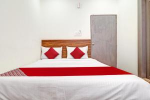 um quarto com uma cama grande com travesseiros vermelhos em Hotel O Lavish Stay em Surūrnagar mais 44 fotografias