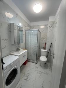 un bagno bianco con un water e un lavandino di Apartment nou 2 camere a Chiajna