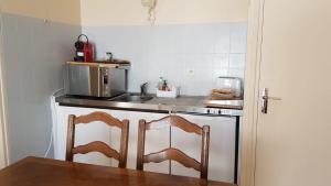 cocina con fregadero y encimera con 2 sillas en Le Petit HERMITAGE - Gite 4 pers, en Massiac