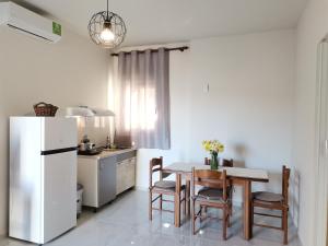 a kitchen with a table and chairs and a refrigerator at La Maison de Christine -Adults Only in Chrysi Ammoudia