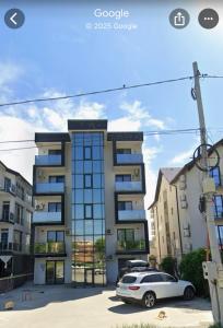 een witte auto geparkeerd voor een gebouw bij Apartments 1 Mamaia Nord in Mamaia Nord – Năvodari