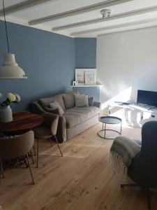 a living room with a couch and a table at Cottage at Sea in Noordwijk aan Zee
