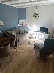 a living room with a couch and a table at Cottage at Sea in Noordwijk aan Zee