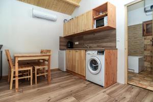 a kitchen with a table and a washing machine at Adlin in Homokcsárda