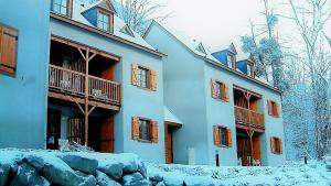 a blue building with snow on the ground at Les Estives de Cauterêts in Cauterets