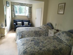 a hotel room with a bed and a couch at Kingswood Cottage in Lyndhurst