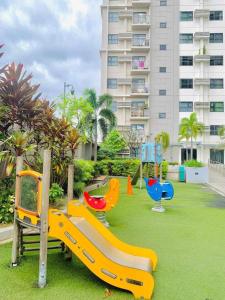 a playground with slides on a lawn in front of a building at mrbed in Cebu City +23 photos