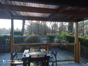Un patio con una mesa y sillas en una terraza. en Chalet RUISSEAU 02, en La Teste-de-Buch