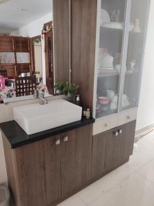 une salle de bain avec un lavabo blanc et un meuble dans l'établissement Sivarama gaeden resort 5 star stay & swimming pool room no 5 bheemunipatbam beach road to dorathota road, à Bhīmunipatnam