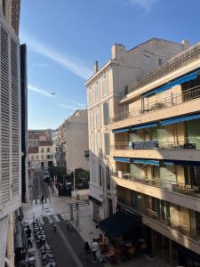 a view of a city street with tables and buildings at Studio au cœur de Cannes in Cannes