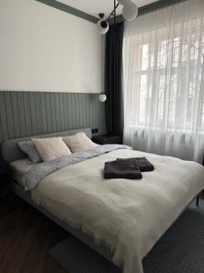 a bedroom with a white bed with a window at Marijas Designer Apartment - Quiet Luxury in the Heart of Riga in Rīga