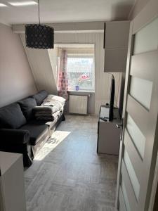salon z kanapą i oknem w obiekcie NaturHouse Poznań w Poznaniu