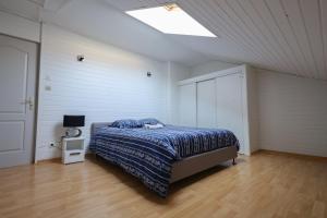 a bedroom with a bed with a blue comforter at L'émeraude in Loyettes
