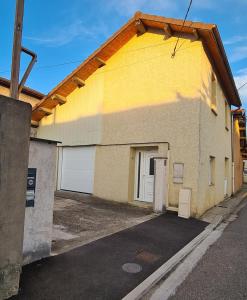 a yellow and white building with a garage at L'émeraude in Loyettes