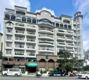 a large building with cars parked in front of it at LJ's Burnham Homestay in Baguio