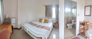 a white bedroom with a bed and a toilet at M-Plus Homestay Sukhothai in Sukhothai
