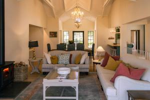a living room with couches and a chandelier at Klein River Cottage, Stanford Getaway in Stanford